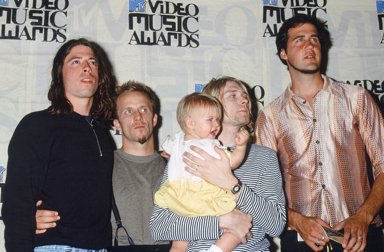 Les membres de Nirvana lors des 10e MTV Video Music Awards (1993, Los Angeles). Au centre, Kurt Cobain et sa fille Frances Bean Cobain. 